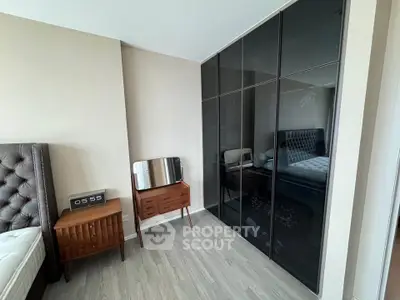 Modern bedroom with sleek black wardrobe and stylish wooden furniture