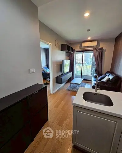 Modern living room with city view, sleek furniture, and wooden flooring