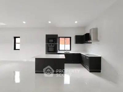 Modern kitchen with sleek black cabinetry and open layout design.