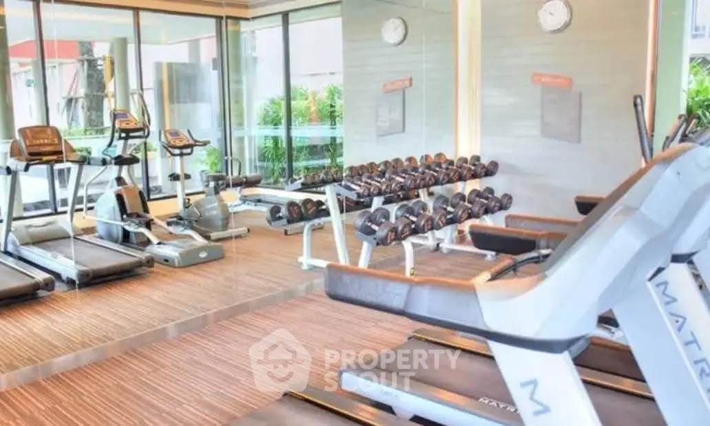 Modern gym with state-of-the-art equipment and mirrored walls in a luxury residential building.