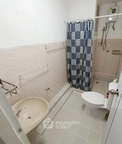 Compact bathroom with shower and checkered curtain in cozy apartment.