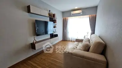 Modern living room with stylish TV unit and cozy sofa, featuring elegant decor and natural light.