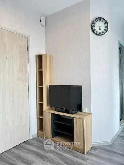 Modern living room with sleek TV stand and wall clock, showcasing minimalist design.
