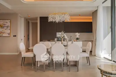 Luxurious dining area with elegant chandelier and modern kitchen in open layout