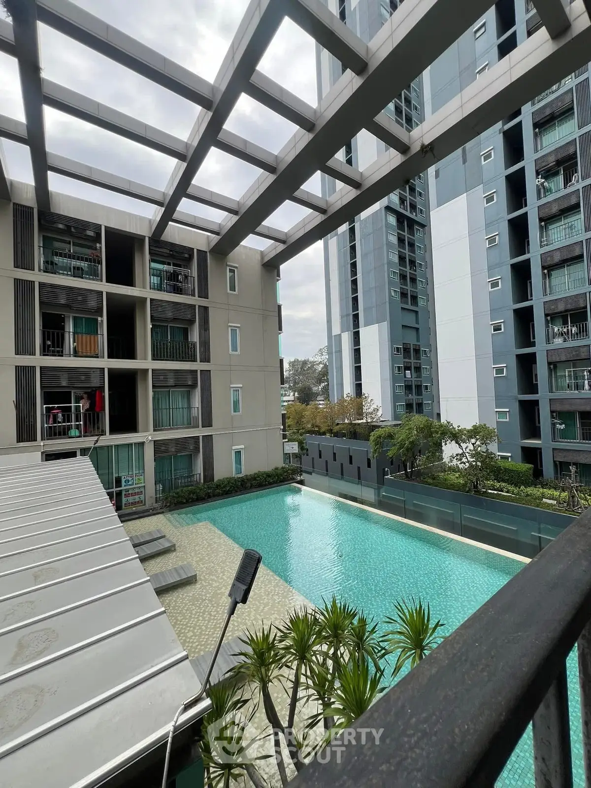 Modern apartment complex with a stunning pool view and lush greenery.