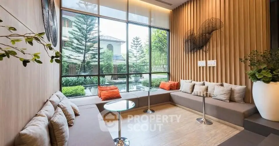 Stylish modern living room with large windows and garden view, featuring cozy seating and elegant decor.