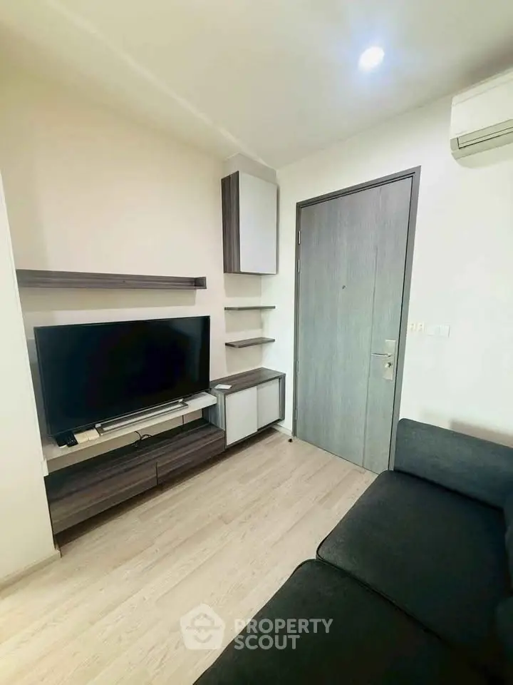 Modern living room with sleek TV unit and cozy sofa in a stylish apartment.