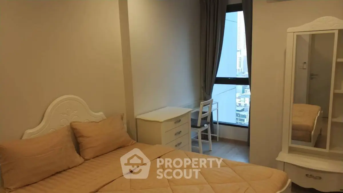 Cozy bedroom with city view, featuring elegant furnishings and natural light.