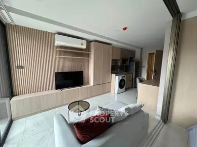 Modern living room with sleek design, featuring a washing machine and open kitchen layout.