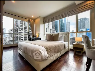 Luxurious bedroom with city view and elegant furnishings in high-rise apartment.