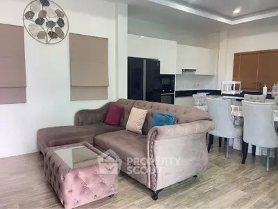 Elegant living room with plush sofa and modern kitchen in open layout