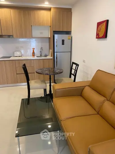 Modern open-layout kitchen and living room with stylish furniture and appliances.