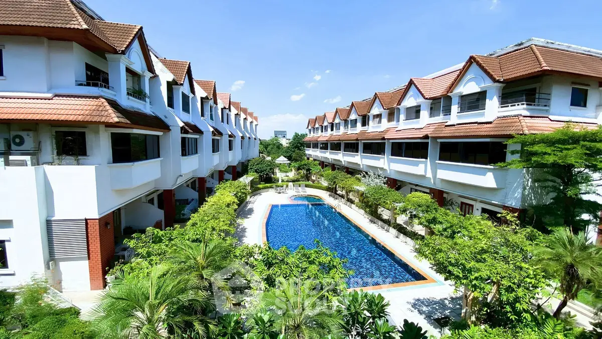Stunning residential complex with lush greenery and inviting pool, perfect for luxury living.