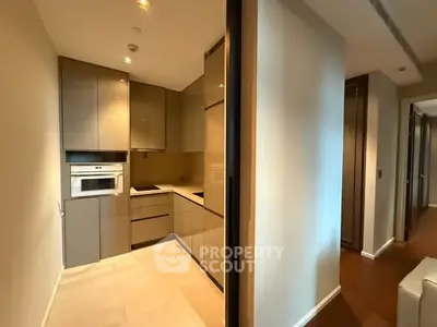 Modern kitchen with sleek cabinetry and built-in oven in a contemporary apartment.