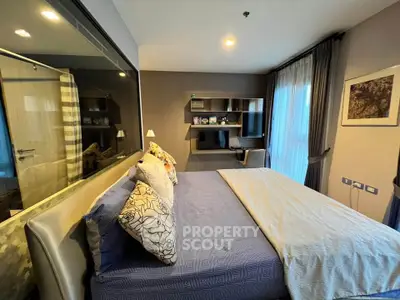 Modern bedroom with stylish decor and large window offering natural light