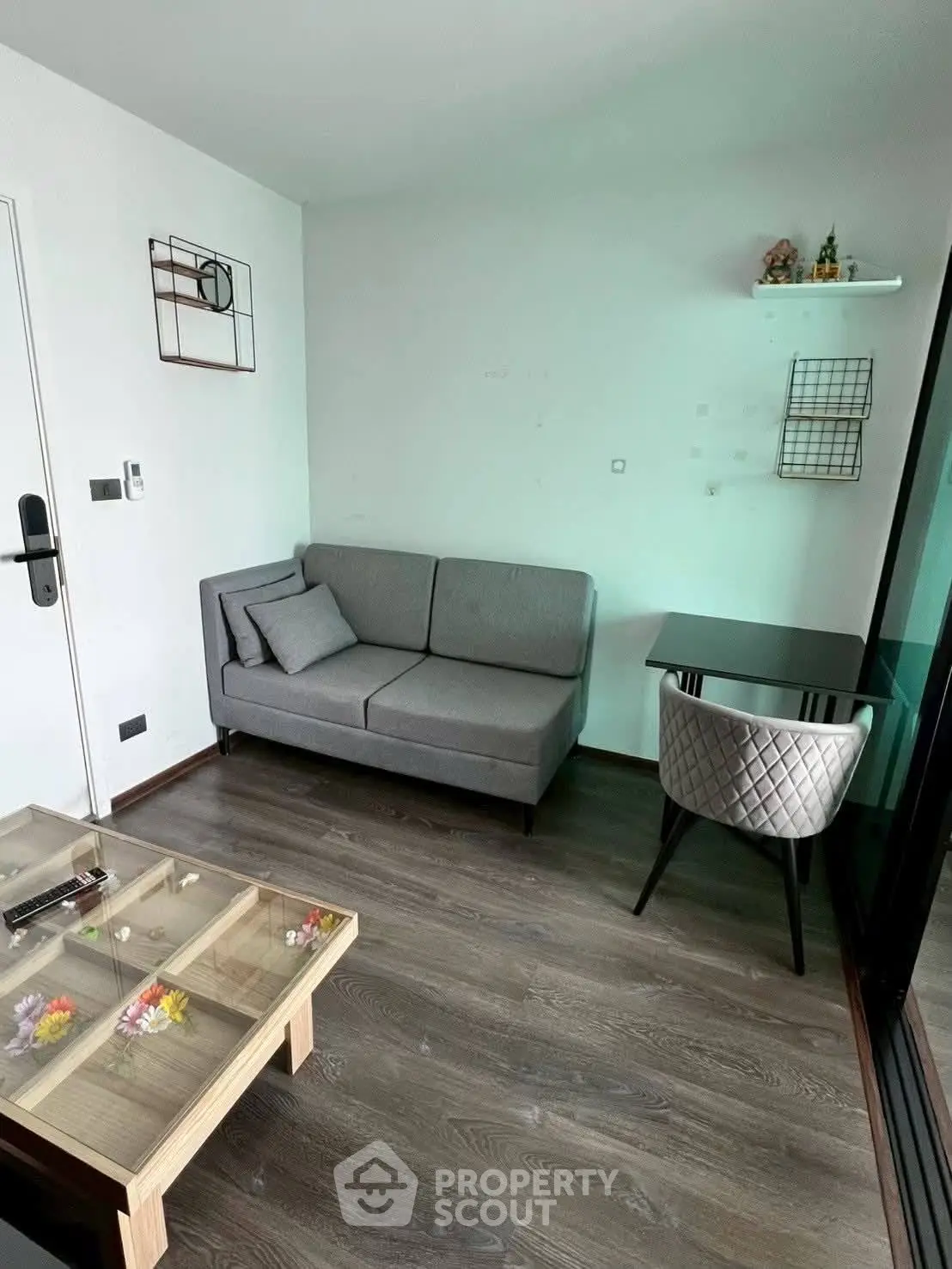 Cozy modern living room with stylish furniture and glass coffee table, perfect for urban living.