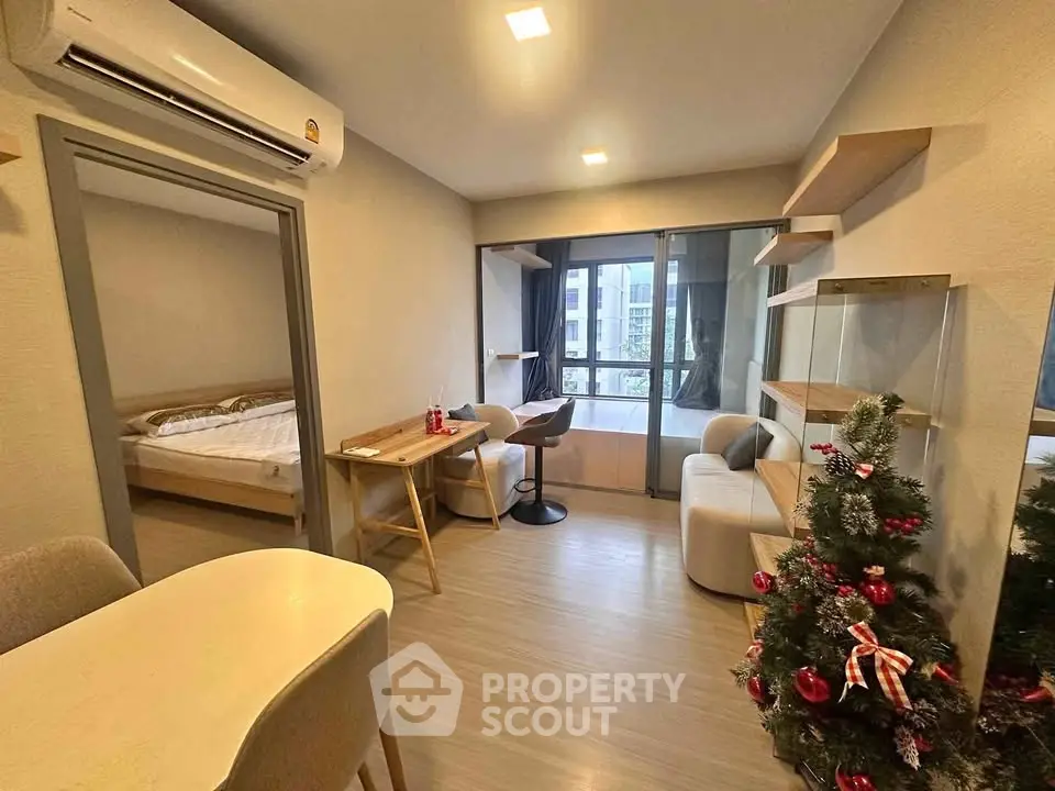 Modern living room with festive decor and view of bedroom, ideal for cozy urban living.