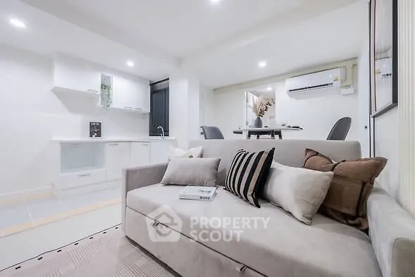 Modern living room with stylish sofa and open kitchen layout, perfect for contemporary living.