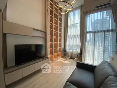 Spacious modern living room with high ceilings and large windows in a luxury apartment.