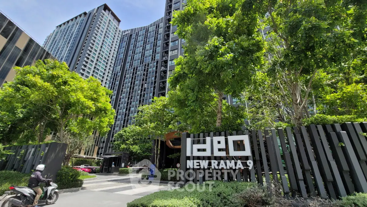 Modern high-rise building with lush greenery at Ideo New Rama 9