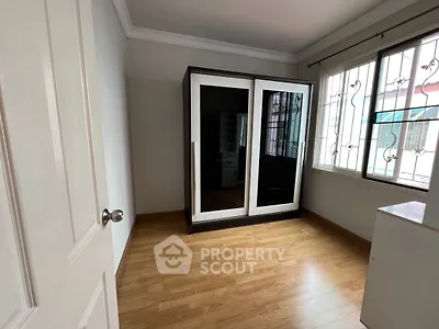 Spacious bedroom with mirrored wardrobe and wooden flooring