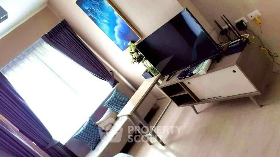 Modern living room with stylish decor and large TV, perfect for relaxation and entertainment.