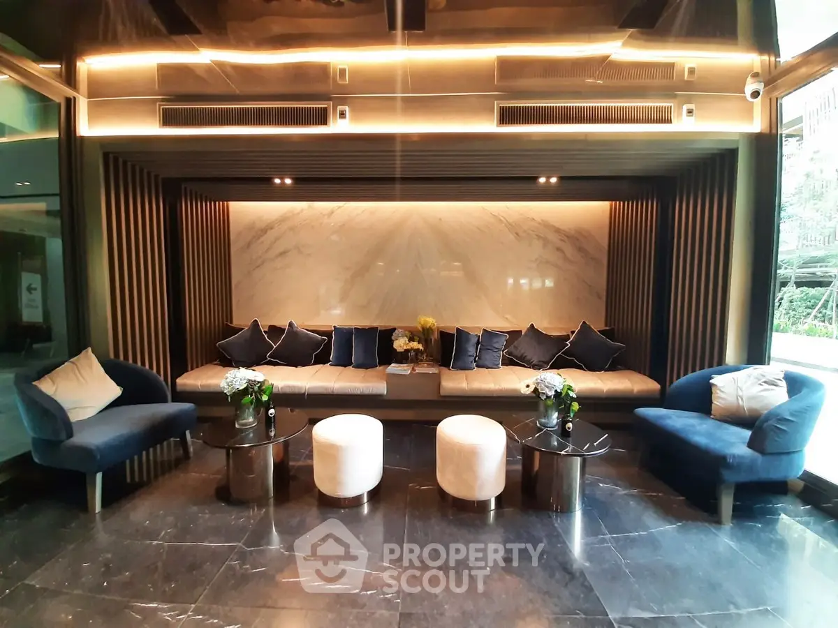 Luxurious modern lobby with elegant seating and marble accents in a high-end residential building.