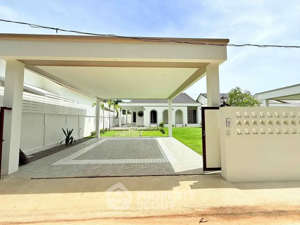 Stunning modern villa with spacious driveway and lush green lawn, perfect for luxury living.