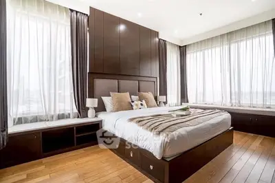 Luxurious bedroom with large windows and elegant wooden furnishings