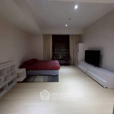 Spacious modern bedroom with minimalist decor and large window view.