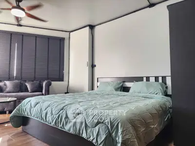 Spacious bedroom with modern decor and cozy seating area, perfect for relaxation.