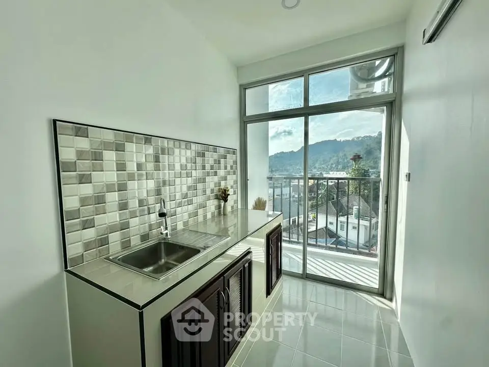 Modern kitchen with scenic view and sleek design, featuring a stylish backsplash and ample natural light.