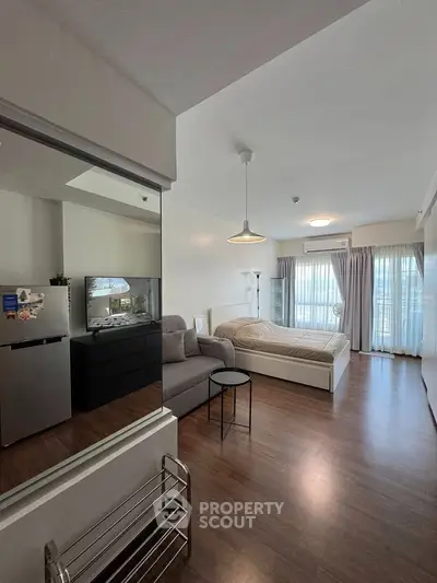 Modern studio apartment with cozy bed and natural light