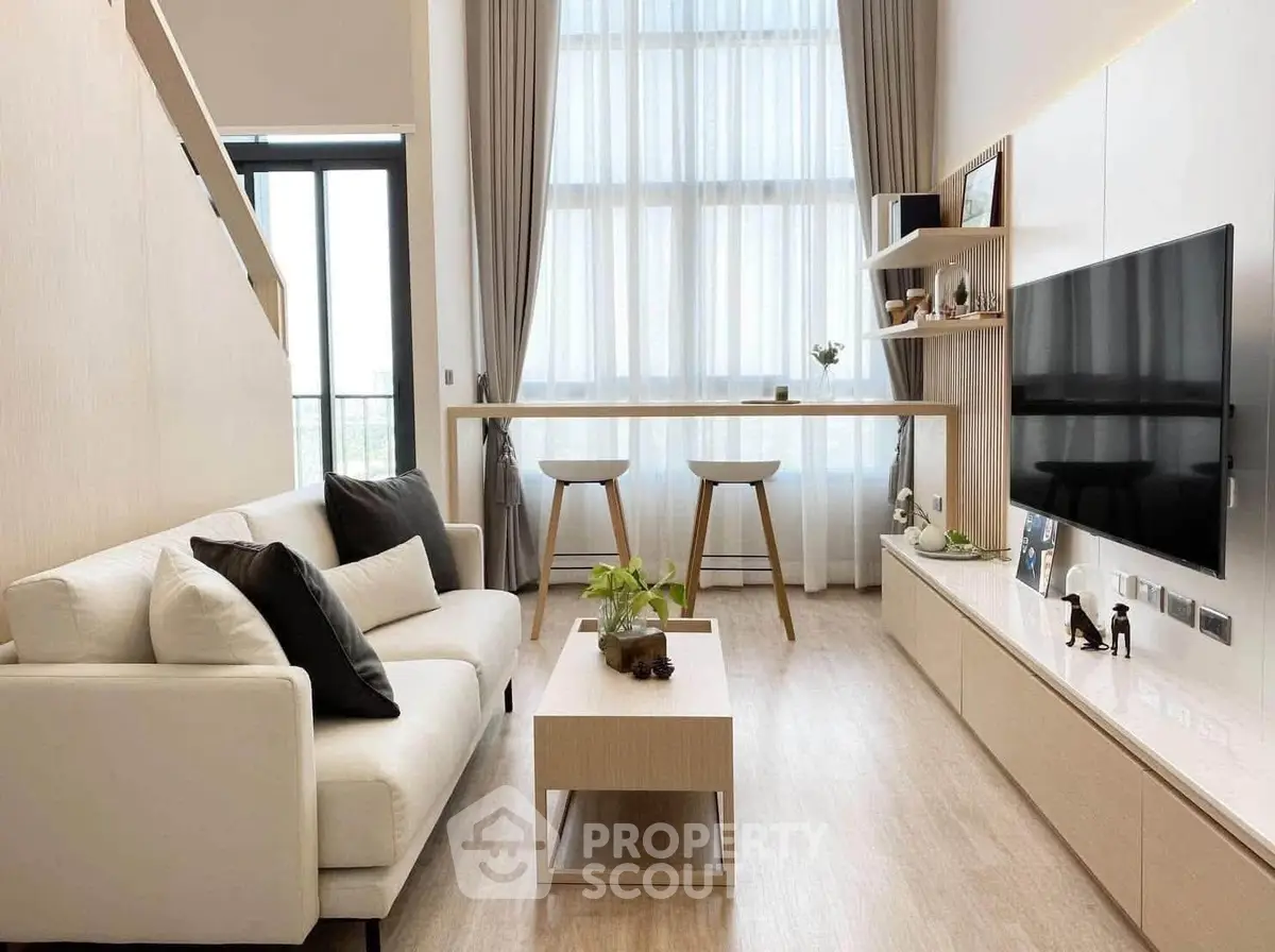 Modern living room with high ceilings and stylish decor in a luxury apartment.
