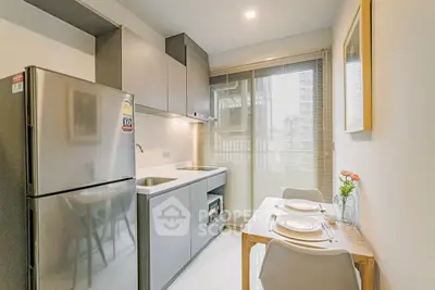 Modern kitchen with sleek cabinetry and dining area in a bright apartment