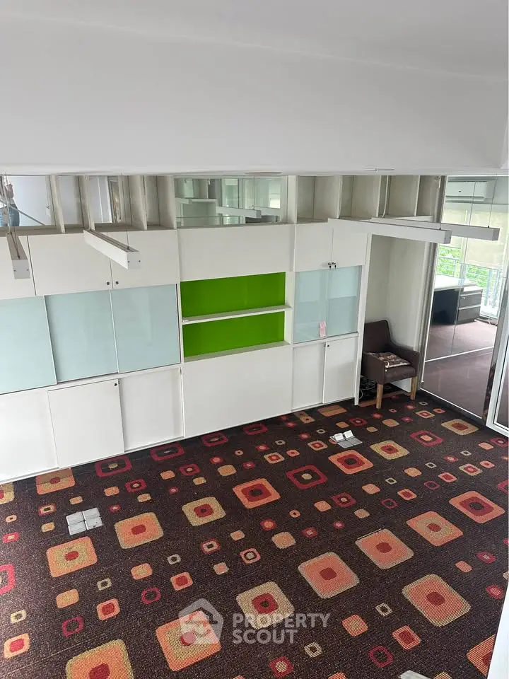 Spacious living room with modern carpet and built-in storage, featuring large windows for natural light.