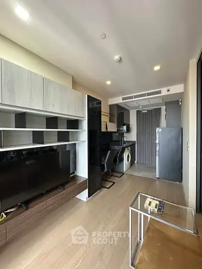 Modern open-layout living room with sleek kitchen and stylish furniture in a contemporary apartment.