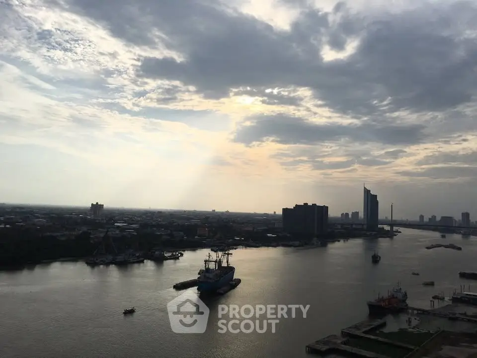 Stunning river view with city skyline under dramatic cloudy sky, perfect for urban living enthusiasts.