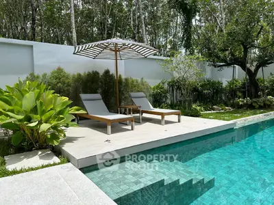 Luxurious poolside with sun loungers and lush greenery in a serene garden setting.