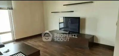 Modern living room with wooden flooring and sleek TV setup