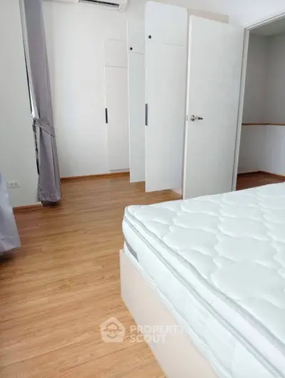 Spacious bedroom with wooden flooring and ample closet space