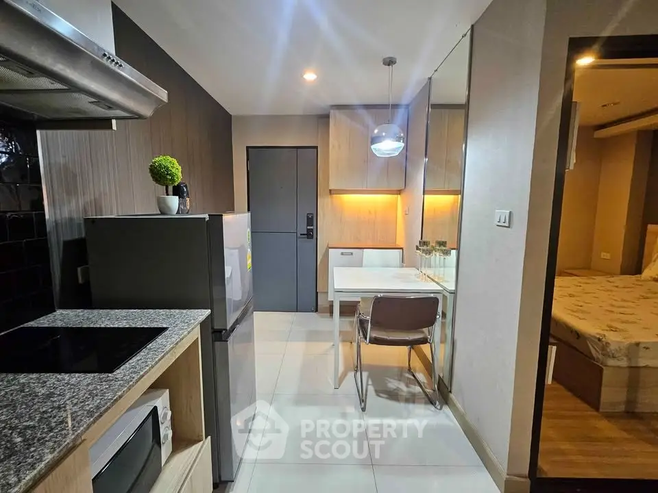 Modern apartment interior with compact kitchen and cozy dining area, featuring sleek appliances and stylish decor.