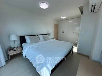 Spacious bedroom with modern furnishings and ample natural light