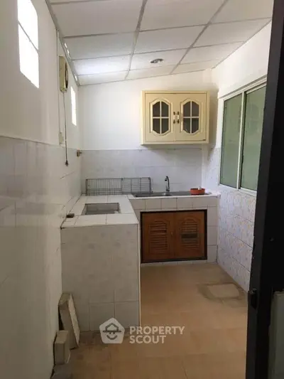 Compact kitchen with closed layout and tiled walls