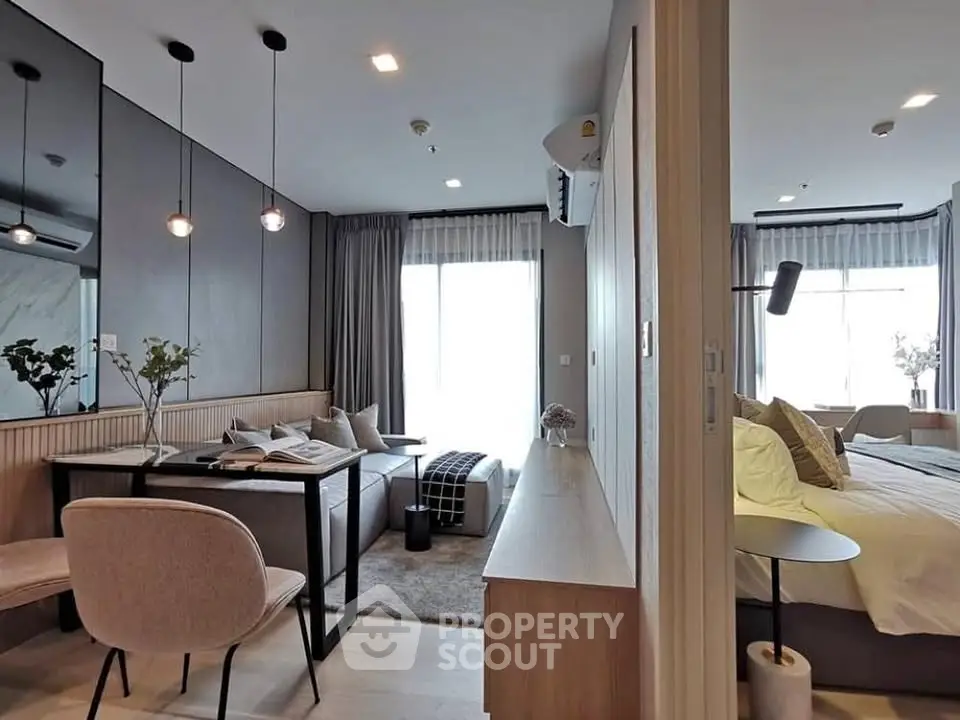 Modern open-plan living room and bedroom with stylish decor and natural light.