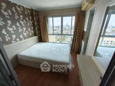Spacious bedroom with large window offering stunning city views, featuring elegant wallpaper and wooden flooring.