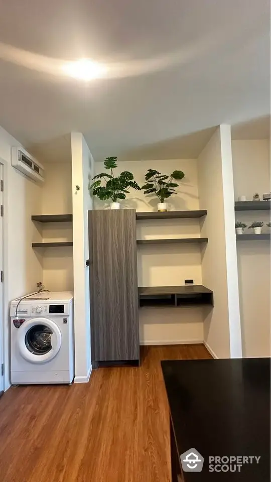 Modern interior with washing machine and stylish shelving in compact space