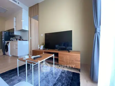 Modern living room with sleek furniture and large TV, featuring a cozy ambiance and stylish decor.