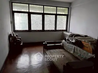 Spacious room with large windows and wooden flooring, ideal for customization.