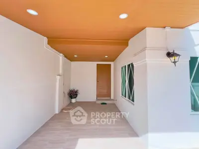 Modern entrance with stylish lighting and wooden door in a contemporary home.